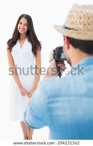 Hipster taking a photo of pretty girlfriend on white background