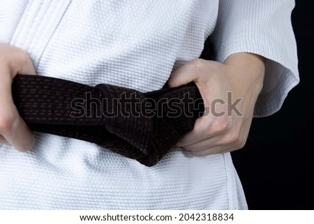Ju Jitsu fighter. Womans holding a Brown belt wearing a Kimono. Martial arts  fighter Royalty-Free Stock Photo #2042318834