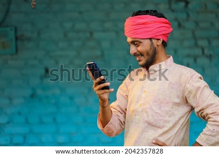 Technology concept : Indian farmer using smartphone Royalty-Free Stock Photo #2042357828