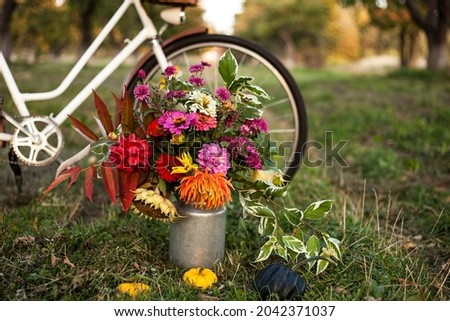 a  vintage bicycle with a bouquet of autumn flowers in a basket 