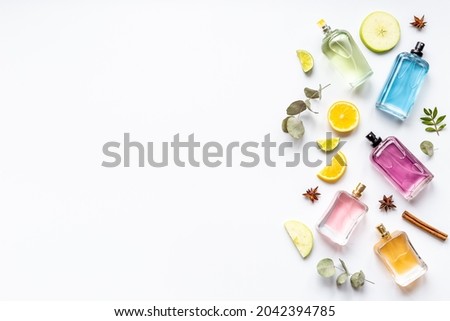 Perfume bottles with flowers leaves and fruits. Overhead view Royalty-Free Stock Photo #2042394785