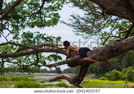 Asian boy sleeping on a tree. boy sleeping take a rest