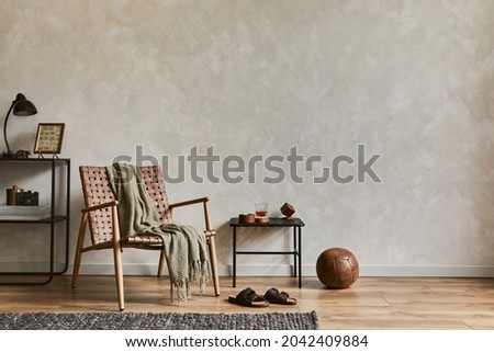 Stylish composition of elegant masculine living room interior with copy space, brown armchair, industrial shelfs and personal accessories. Template.   Royalty-Free Stock Photo #2042409884