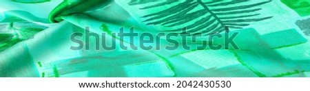 green fabric with an abstract pattern, a print of branches with leaves of flora. Background texture. Background. Template.