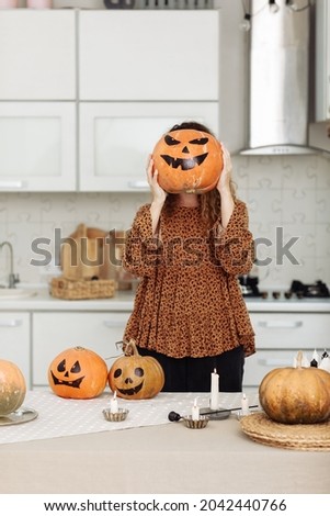 woman having fun with painted pumpkins at home on Halloween. Thanksgiving or halloween. Harvesting time on autumn. selective focus.