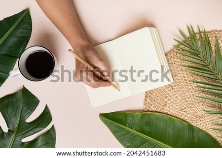 Tropical workspace concept. Notepad and tropical palm leaves. Mockup presentation workplace.