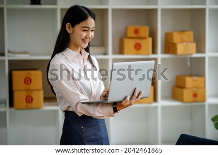 Starting Small business entrepreneur SME freelance,Portrait young woman working at home office, BOX,smartphone,laptop, online, marketing, packaging, delivery, b2b,SME, e-commerce concept.