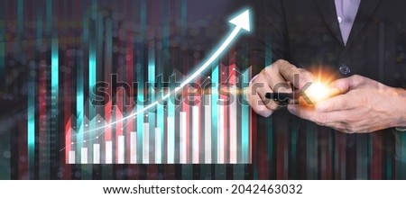 Double exposure of businessman using the tablet with cityscape and financial graph on blurred building background, Business Trading concept