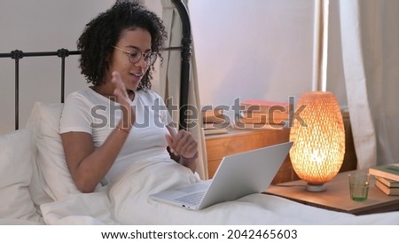 Video Call on Laptop by Young African Woman in Bed