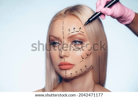Beautiful blonde woman with markings for plastic surgery on her face Royalty-Free Stock Photo #2042471177
