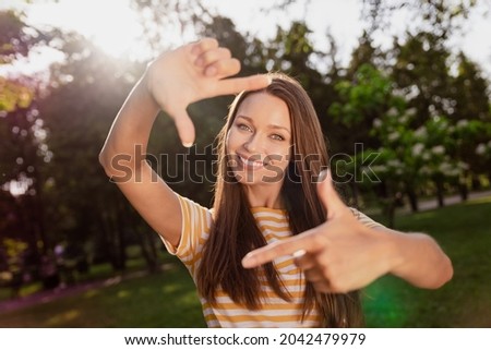 Portrait of attractive cheerful girl having fun showing frame capture good mood rest vacation outdoors