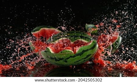 A ripe watermelon falls to the floor and smashes to pieces.. Freeze motion. Royalty-Free Stock Photo #2042505302