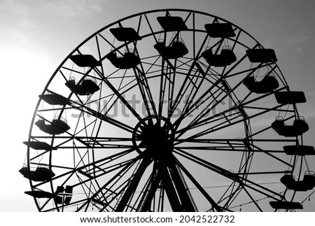 Ferris wheel of the amusement park with the seats that turn but without people with effect in white and black