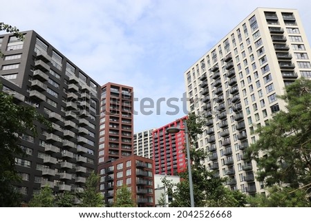An urban city image of a group of coloured high rise buildings clustered together.  Trees fringe the lower portion of the image.