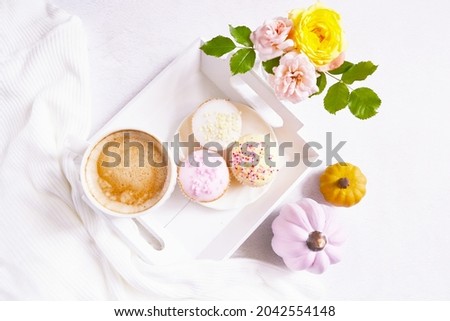 Cup of coffee, pink pumpkins, roses bouquet, cupcakes on the white background. Feminine atmosphere. Woman power. Happy Halloween. Girlish fall composition. Coffee break at home. Holiday girly concept.