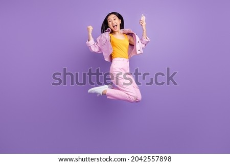 Full body profile photo of hooray millennial brunette lady jump wear jacket jeans sneakers isolated on violet background Royalty-Free Stock Photo #2042557898