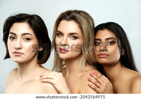 Multi-ethnic beauty and friendship. Group of beautiful different ethnicity women on gray background.