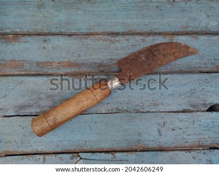 An old traditional knife on a blue wooden table.