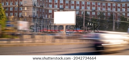 Horizontal billboard next to the road with blurred cars, mockup with advertising space.
