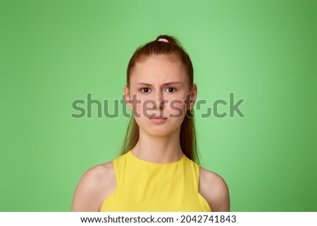 sad teen girl on green background. Human emotions