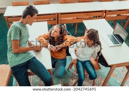 Top view photo of group of school kids learning on laptop with their teacher during a class in the classroom. Selective focus . High quality photo