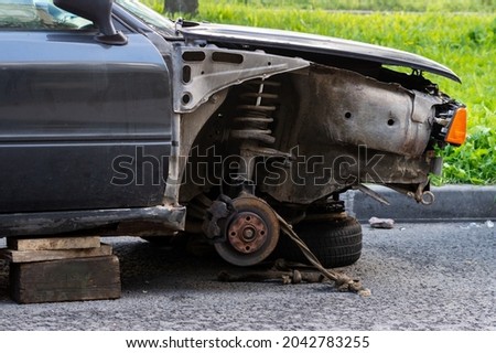 a broken car without wheels on the street. High quality photo