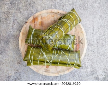 rice mixed with coconut milk wrapped in banana leaves and steamed, a typical Indonesian street food, often served during Eid, in Indonesian it is called "Buras" Royalty-Free Stock Photo #2042819390