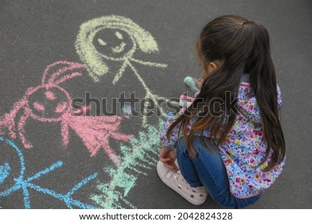 Child drawing family with chalk on asphalt Royalty-Free Stock Photo #2042824328