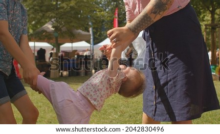 Mom and son ride on the arms and legs of a little girl. Increasing the tone of the child's body, joint flexibility, muscle stretching. Mom makes a kiss on the lips.