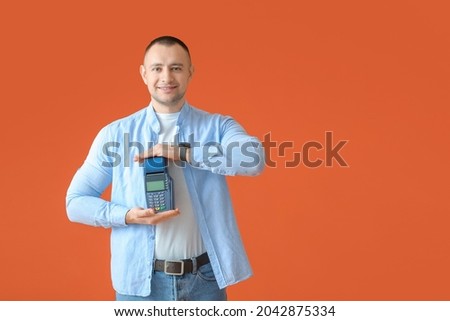 Man with payment terminal on color background