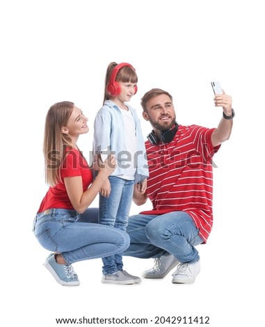 Happy family with mobile phones and headphones taking selfie on white background