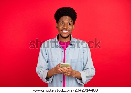 Photo of young afro guy happy positive smile use cellphone social media blogger isolated over red color background
