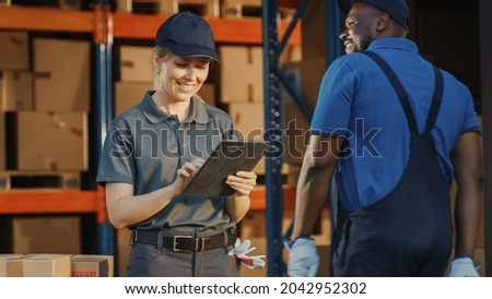 Female Manager Using Tablet Computer To Check Inventory. Warehouse Retail Center with Cardboard boxes,  e-Commerce Online Orders, Food. Frontline Hero. Royalty-Free Stock Photo #2042952302
