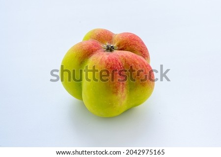 The interesting, unusual, strange apple. An ugly apple surrounded by ordinary ones. The photo symbolizes individuality, leadership, personal characteristics, self-acceptance.