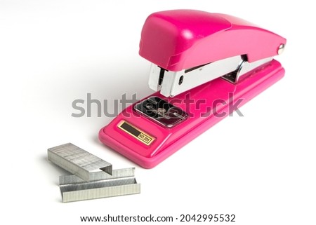 Stapler and metal staple concept over white background.