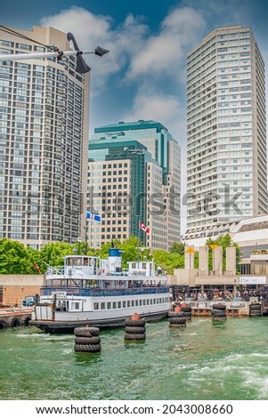 Ferry boat docked at Toronto harbour front with high rise buildings in the background