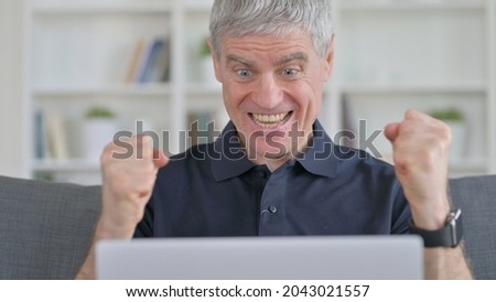 Middle Aged Man Celebrating Success on Laptop 