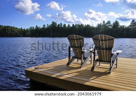 Back view of wooden chairs in a dock in a sunny day Royalty-Free Stock Photo #2043061979