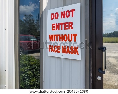 Do not enter, mask or face covering required sign near the entry door of business. Corona Virus (COVID-19) has prompted many retailers and small businesses to mandate cloth face coverings.