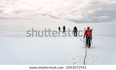 Group of mountaineers on a rope. Summer glacier trekking on Grossvenediger Mountain, Hohe Tauern National Park, Austrian Alps