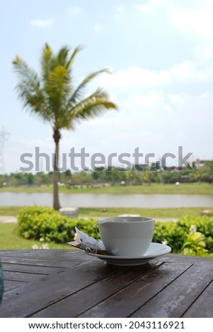 a glass of hot tea with a lake view
