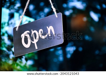 A shop label ‘Open’ which hanging on the glass door of the shop, concept for informing people in Covid-19 crisis situations around the world.