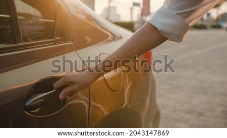 Successful young Asia businesswoman commuter in fashion office clothes entering a taxi or getting into a cab outdoors in urban modern city in the morming. Business on the go to work concept. Royalty-Free Stock Photo #2043147869
