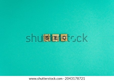 Word SEO. The phrase is laid out in wooden letters. Top view. Motivation. Blue background. Copy space.