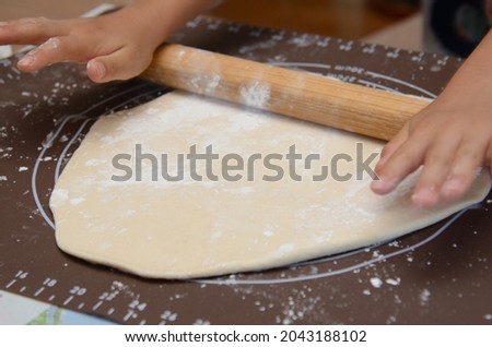 Both hands of elementary school students knead the dough
