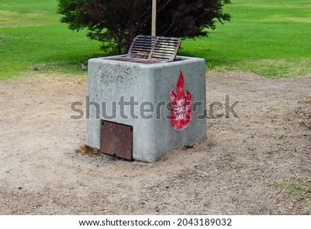 A heavy duty barbecue grill made of stone and concrete at a park.
