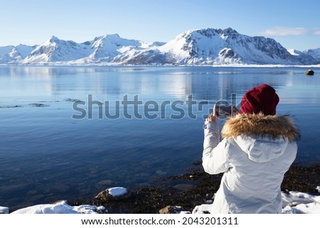 girl travels around lofoten islands and takes pictures on camera. beautiful Norwegian landscape. Norway
