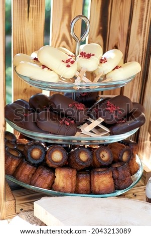Vase with desserts. Cake pops in white and dark chocolate and cute cannele.
