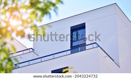 Ecological housing architecture. A modern residential building in the vicinity of trees. Ecology and green living in city, urban environment concept. Modern apartment building and green trees. Royalty-Free Stock Photo #2043224732