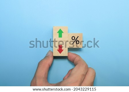 hand holding wooden cube with red arrow.investment concept